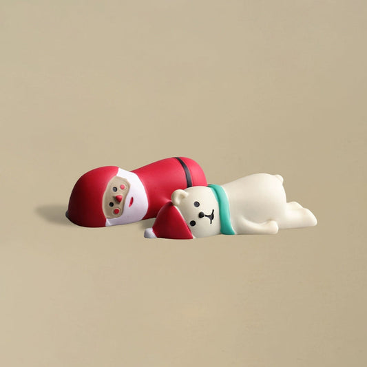 Santa Claus and a polar bear lying down together in a playful pose, charming Christmas decoration.
